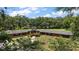 Aerial view of a large home in a rural setting surrounded by mature trees and green pastures with stone accents at 672 E Belt Ave, Bushnell, FL 33513