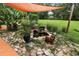 Backyard landscaping with a rock pond featuring a waterfall, goldfish, potted plants and yard ornaments at 672 E Belt Ave, Bushnell, FL 33513