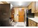 This laundry room features tile floors, wood cabinets, stainless steel appliances, and direct access to the outside at 672 E Belt Ave, Bushnell, FL 33513