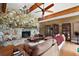 Spacious living room featuring a stone fireplace, hardwood floors, ceiling fan, and glass display cabinets at 672 E Belt Ave, Bushnell, FL 33513