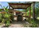 This outdoor kitchen features a built-in grill, serving areas and mature landscaping around the outdoor grilling area at 672 E Belt Ave, Bushnell, FL 33513
