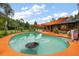 Large pool with unique features, poolside lounge area, outdoor bar, sun shades, and lush landscaping at 672 E Belt Ave, Bushnell, FL 33513