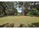 Expansive backyard with mature trees offers a serene and private outdoor space at 672 E Belt Ave, Bushnell, FL 33513