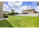 Large, well-manicured backyard with a white fence and a view of the neighboring houses under a bright sky at 752 Sandy Bar Dr, Winter Garden, FL 34787