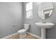 Bathroom features a toilet, pedestal sink, and a round mirror at 752 Sandy Bar Dr, Winter Garden, FL 34787