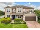 Charming two-story home with well-maintained landscaping and a brick driveway leading to a two-car garage at 752 Sandy Bar Dr, Winter Garden, FL 34787