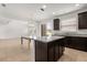 Modern kitchen island with granite countertops and dark cabinets, adjacent to the living area and a sliding glass door at 752 Sandy Bar Dr, Winter Garden, FL 34787