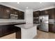 Elegant kitchen with stainless steel appliances, granite countertops, and ample dark wood cabinet space at 752 Sandy Bar Dr, Winter Garden, FL 34787