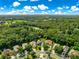 Aerial view showing property surrounded by lush landscaping in a desirable neighborhood with mature trees and manicured lawns at 8045 Waterbury Way, Mount Dora, FL 32757