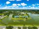 View of a community featuring a lakefront recreational area with tennis courts, a clubhouse, and other amenities at 8045 Waterbury Way, Mount Dora, FL 32757
