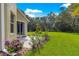 Landscaped backyard with lush green lawn and view of the home's patio at 8045 Waterbury Way, Mount Dora, FL 32757