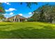 Spacious backyard with a well-maintained lawn and view of the home at 8045 Waterbury Way, Mount Dora, FL 32757