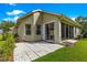 Exterior view of the house from the backyard with a stone patio and mature landscaping at 8045 Waterbury Way, Mount Dora, FL 32757