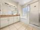 Bright bathroom featuring a double vanity, a shower with a glass door, and a soaking tub at 8045 Waterbury Way, Mount Dora, FL 32757
