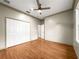 Bedroom boasts spacious closet, wood floors, neutral walls, and a ceiling fan at 8045 Waterbury Way, Mount Dora, FL 32757