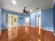 Bedroom with hardwood floors and light blue walls, offering a view of other rooms at 8045 Waterbury Way, Mount Dora, FL 32757