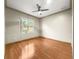 Bright bedroom features wood floors, ceiling fan, and natural light from the exterior window at 8045 Waterbury Way, Mount Dora, FL 32757
