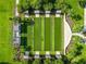 Aerial view of manicured bocce ball courts with shade structures and lush landscaping in a tranquil setting at 8045 Waterbury Way, Mount Dora, FL 32757