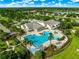 Aerial view of the community pool and clubhouse, featuring meticulously landscaped grounds and palm tree accents at 8045 Waterbury Way, Mount Dora, FL 32757