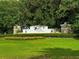Community entrance sign with landscaped flower beds and manicured lawn in a tranquil setting at 8045 Waterbury Way, Mount Dora, FL 32757