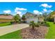 Single Gathering home boasts a well-manicured lawn and mature landscaping at 8045 Waterbury Way, Mount Dora, FL 32757