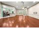 Open-concept living room with hardwood floors and a view into the adjacent kitchen at 8045 Waterbury Way, Mount Dora, FL 32757