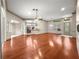 Large living room with hardwood floors, ceiling fan, and an open layout flowing into the kitchen at 8045 Waterbury Way, Mount Dora, FL 32757