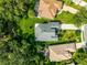 Bird's eye view of a home's roof and backyard, revealing a well-kept lawn and screened-in patio at 8045 Waterbury Way, Mount Dora, FL 32757