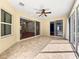 Bright sunroom with tile floors and glass doors offer backyard access and views at 8045 Waterbury Way, Mount Dora, FL 32757
