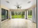 Enclosed sunroom with tile flooring and large sliding glass doors with views of the backyard at 8045 Waterbury Way, Mount Dora, FL 32757