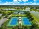 Picture highlighting a community's tennis and basketball courts alongside lush landscaping and scenic water views at 8045 Waterbury Way, Mount Dora, FL 32757