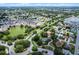 High-angle view of a suburban community, featuring a pond, winding roads, and attractive single-Gathering houses at 8960 Se 178Th Muirfield Pl, The Villages, FL 32162