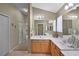 Well-lit bathroom with double sinks, wood cabinets, and neutral decor at 8960 Se 178Th Muirfield Pl, The Villages, FL 32162