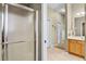 Bathroom including a shower, vanity with solid surface counter, and view into the hallway at 8960 Se 178Th Muirfield Pl, The Villages, FL 32162