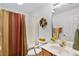 Bathroom featuring a shower with striped curtain, a white toilet with safety handles, vanity and ample lighting at 8960 Se 178Th Muirfield Pl, The Villages, FL 32162