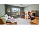 Bedroom with a wooden futon, desk, and a window with natural light, creating a cozy and functional space at 8960 Se 178Th Muirfield Pl, The Villages, FL 32162