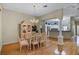 Elegant dining room boasts hardwood floors, a glass table, and a decorative china cabinet with chandelier at 8960 Se 178Th Muirfield Pl, The Villages, FL 32162