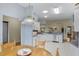 Bright kitchen featuring white cabinets, stainless steel appliances, and a breakfast nook with wood table at 8960 Se 178Th Muirfield Pl, The Villages, FL 32162