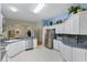 Bright kitchen featuring stainless steel appliances and white cabinets with bar top at 8960 Se 178Th Muirfield Pl, The Villages, FL 32162