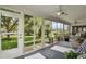 Relaxing lanai featuring full screens with views of the lush yard, ceiling fans, and lounge furniture at 8960 Se 178Th Muirfield Pl, The Villages, FL 32162