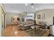 Open-concept living room features hardwood floors, stylish furnishings, and seamless flow to the dining area and kitchen at 8960 Se 178Th Muirfield Pl, The Villages, FL 32162