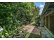 Backyard patio featuring brick pavers, lush greenery, and access to the screened-in lanai at 902 Lakeview Dr, Eustis, FL 32726
