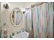 Cozy bathroom featuring a sink, oval mirror and walk-in shower with colorful shower curtain at 902 Lakeview Dr, Eustis, FL 32726