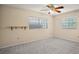 Large bedroom with neutral walls, carpeted floors, a ceiling fan, and two windows at 902 Lakeview Dr, Eustis, FL 32726