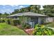View of home's exterior showing the attached garage, manicured lawn, and neatly trimmed hedges at 902 Lakeview Dr, Eustis, FL 32726