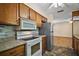Functional kitchen with wood cabinets, updated appliances, granite countertops, and an adjoining living space at 902 Lakeview Dr, Eustis, FL 32726
