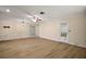 Bright living room with wood flooring features a ceiling fan, overhead lighting, and a door to the exterior at 902 Lakeview Dr, Eustis, FL 32726