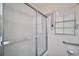 Bathroom shower with a glass door, grab bar, and decorative floral wallpaper border at 902 Lakeview Dr, Eustis, FL 32726
