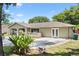 A charming single-story home boasts a lush front yard, freshly landscaped flower beds, and a well-maintained driveway at 910 Rangeline Rd, Longwood, FL 32750