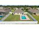 Aerial shot of the backyard featuring a clean in-ground pool surrounded by green lawn and a white fence at 9785 Pepper Tree Trl, Wildwood, FL 34785